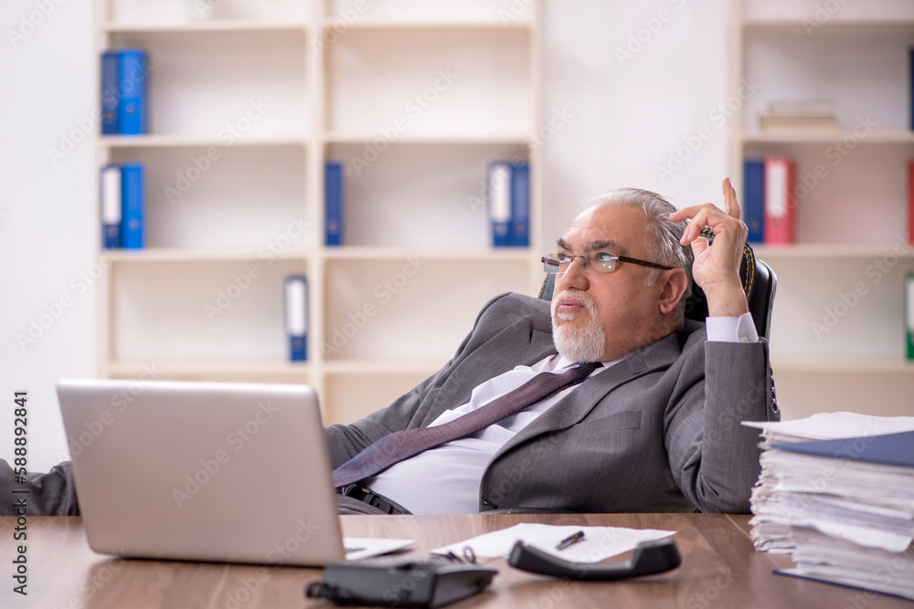 Old male employee working in the office Old male employee working in the office
