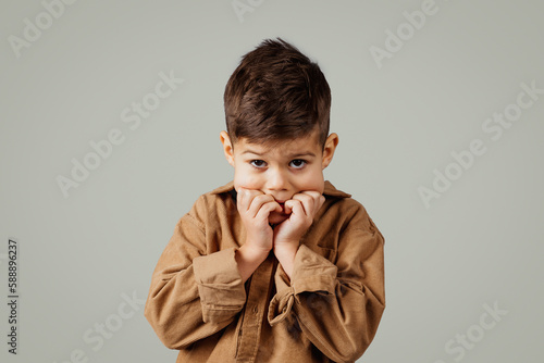 Photography Frightened scared caucasian 6 years old little boy in casual, afraid puts hands