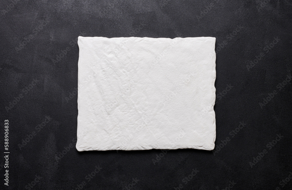 Obraz premium Empty white square ceramic plate on black background, top view