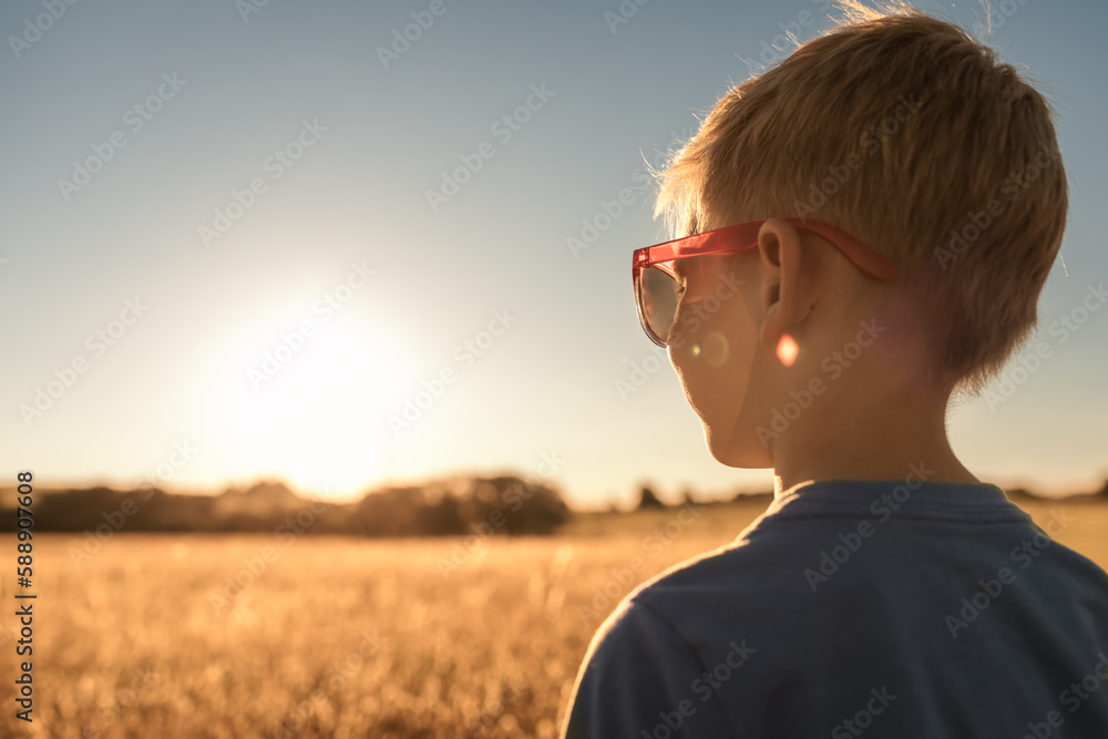 Little boy standing in a open field looking at the view Little boy standing in a open field looking at the view