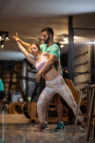 Couple in love dancing bachata and tango. Boy and girl having fun during exercise break in a fitness studio.
