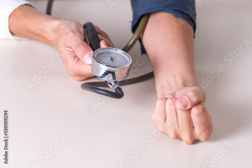 A person holds a blood pressure monitor with the word heart on it
