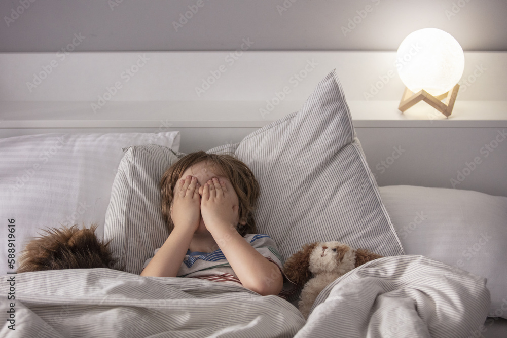 The child was scared. Night terrors in a child. The kid covers his face