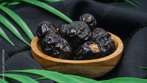 Delicious ajwa dates ( kurma nabi ) or Prophet's Dates. Kurma Ajwa over black fabric texture