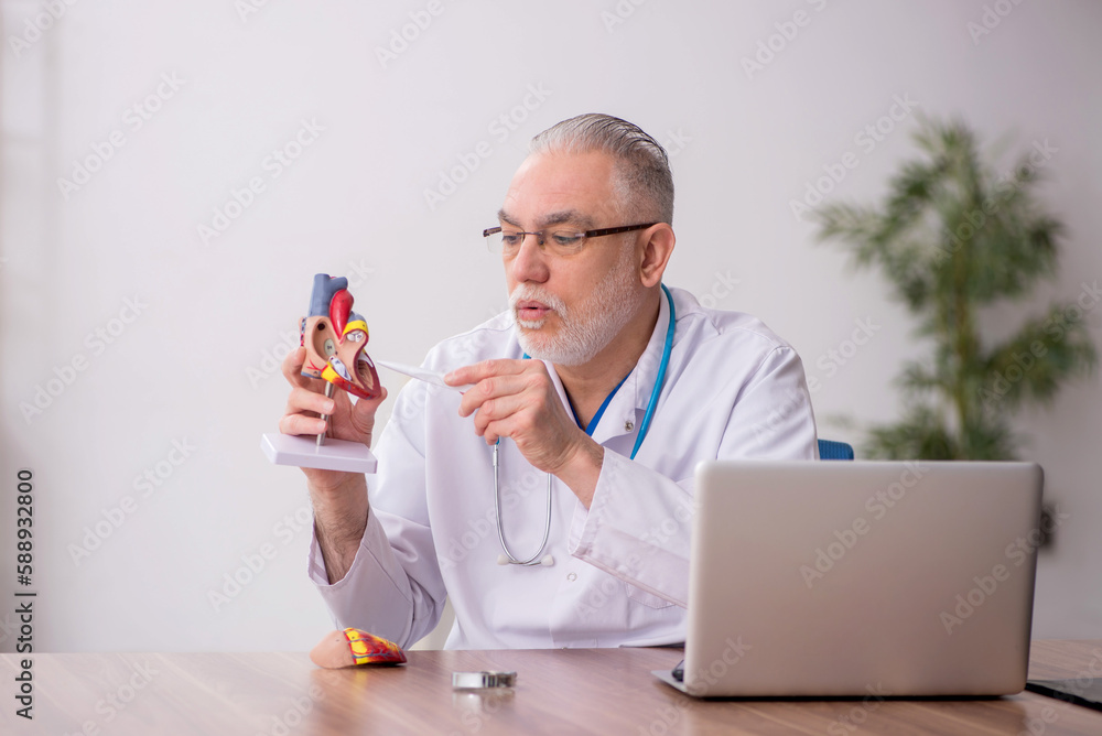 Old male doctor cardiologist working in the clinic Old male doctor cardiologist working in the clinic
