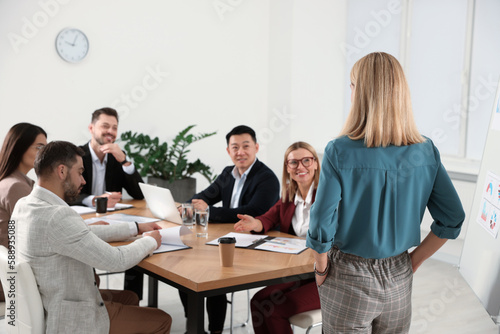 Businesswoman having meeting with her employees in office