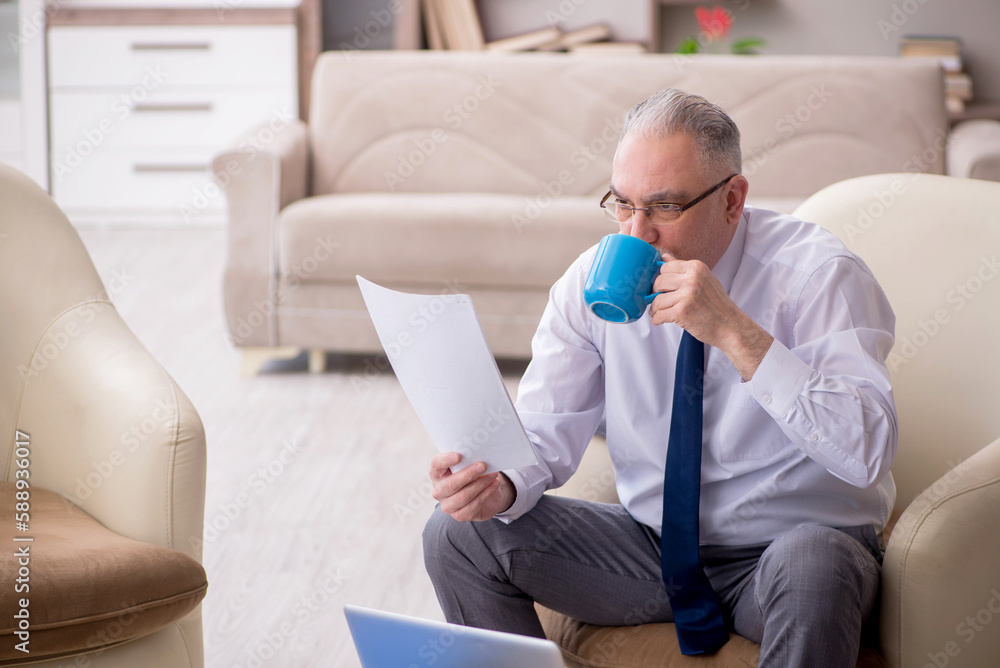 Fototapeta premium Old male boss working from home during pandemic