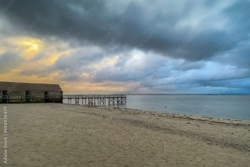 Empty wooden pier with dramatic sky and calm water Empty wooden pier with dramatic sky and calm water