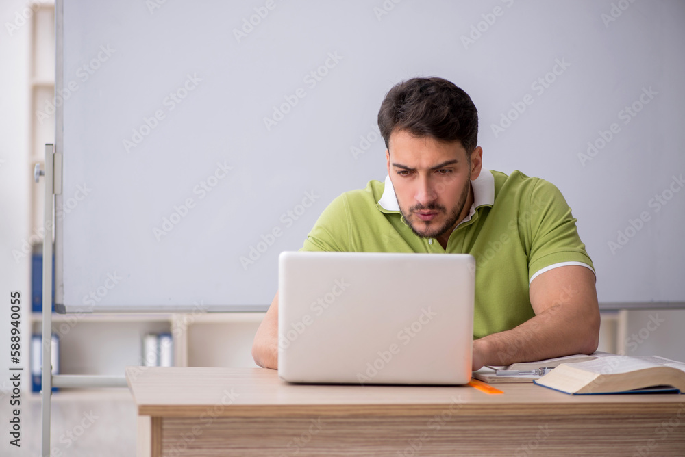 Young male student in telestudying concept Young male student in telestudying concept