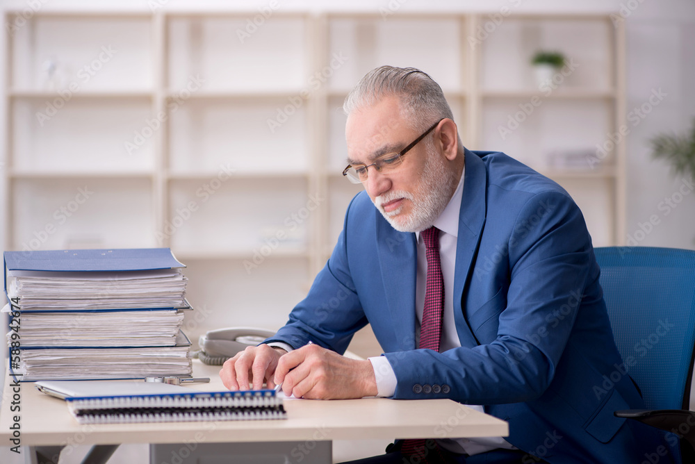 Old male employee and too much work at workplace Old male employee and too much work at workplace