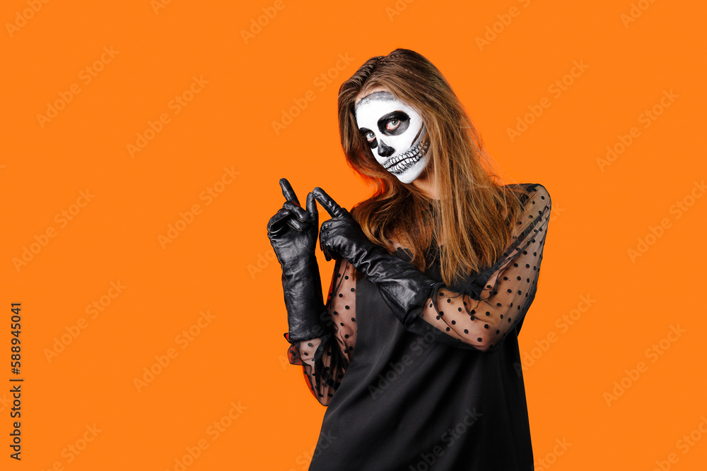 Young beautiful European female wearing casual clothing, defocused, holding orange pumpkin in her hands close-up on gray background. Halloween party concept.