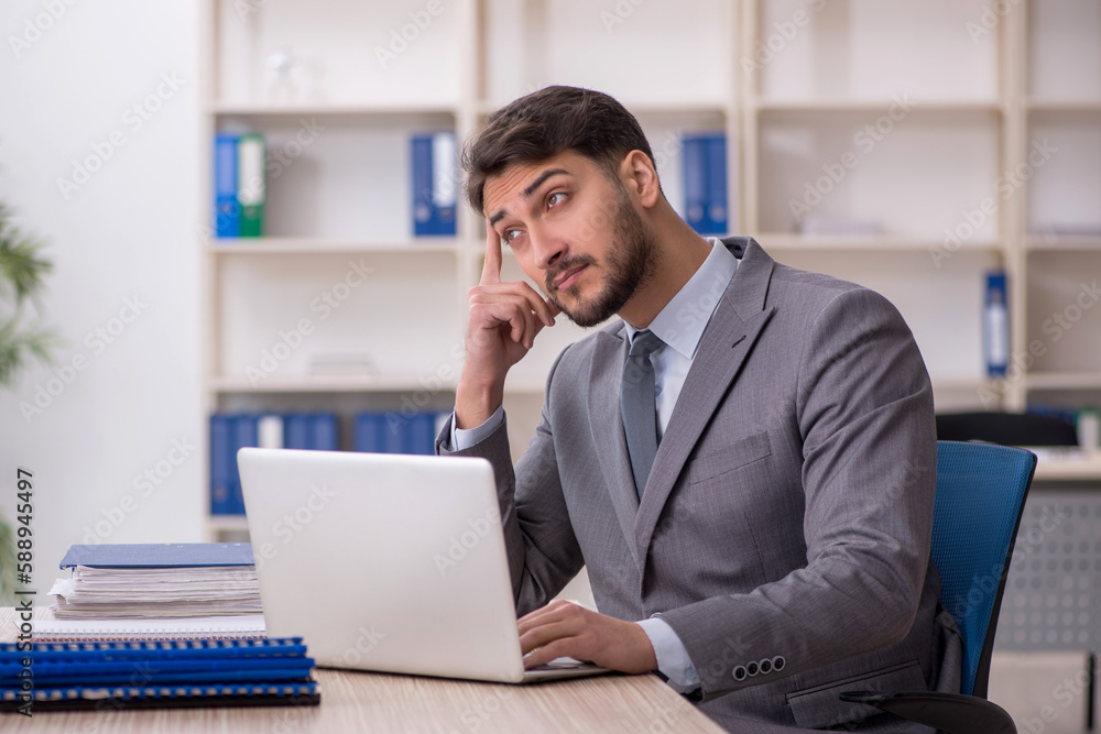 Young male employee working in the office Young male employee working in the office