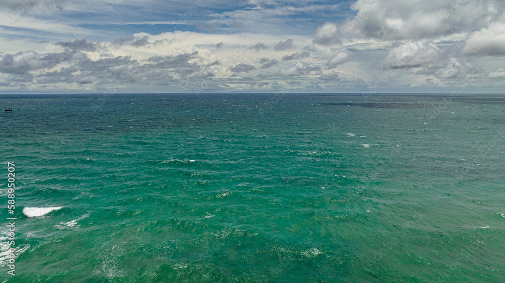Fototapeta premium Blue ocean with waves and blue skies with clouds. Seascape in the tropics. Borneo, Malaysia.