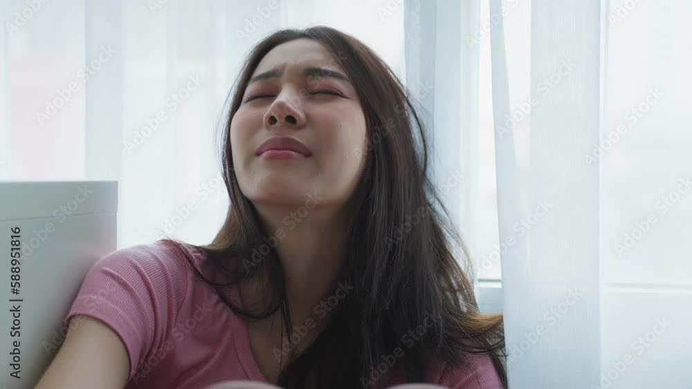 Asian young upset depressed woman sitting alone in living room at home. Asian young upset depressed woman sitting alone in living room at home.