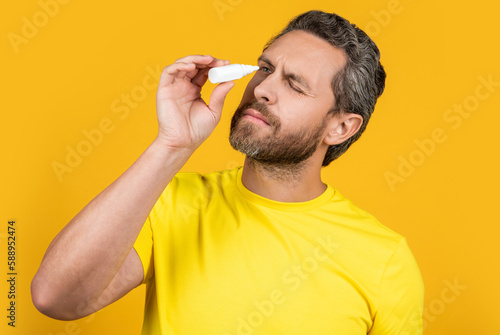 Εκτύπωση καμβά man with eyecare medicine isolated on yellow