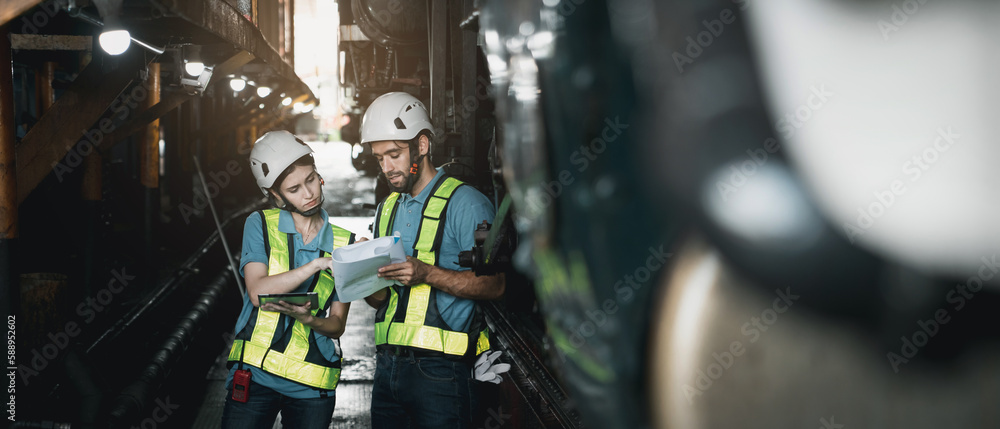 Engineer are working in the factory. Worker helping to repair and inspect the machine's readiness. Mechanical technicians are maintaining the engine in the train garage that is malfunctioning. Engineer are working in the factory. Worker helping to repair and inspect the machine's readiness. Mechanical technicians are maintaining the engine in the train garage that is malfunctioning.