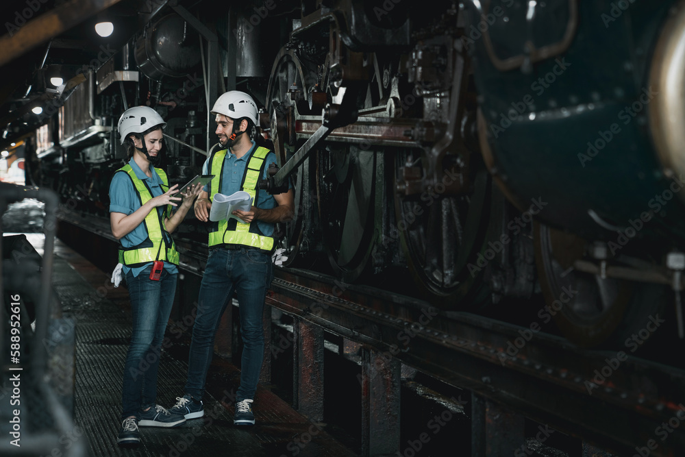 Engineer are working in the factory. Worker helping to repair and inspect the machine's readiness. Mechanical technicians are maintaining the engine in the train garage that is malfunctioning. Engineer are working in the factory. Worker helping to repair and inspect the machine's readiness. Mechanical technicians are maintaining the engine in the train garage that is malfunctioning.