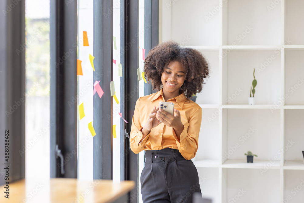 Portrait of Asian business african woman using mobile phone application and pointing finger to smartphone workplace office. Social Networks Financial and tax systems concept.	