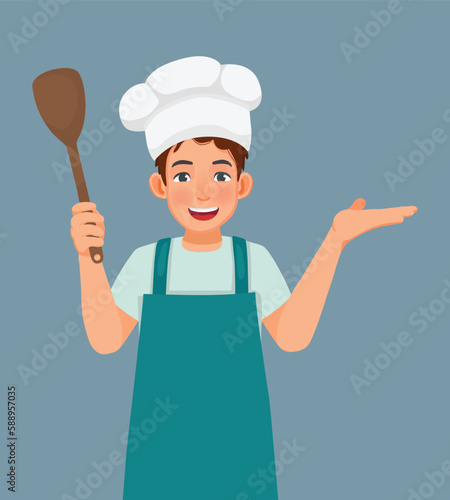 Young man in chef hat and apron holding ladle showing hand for copy space 
