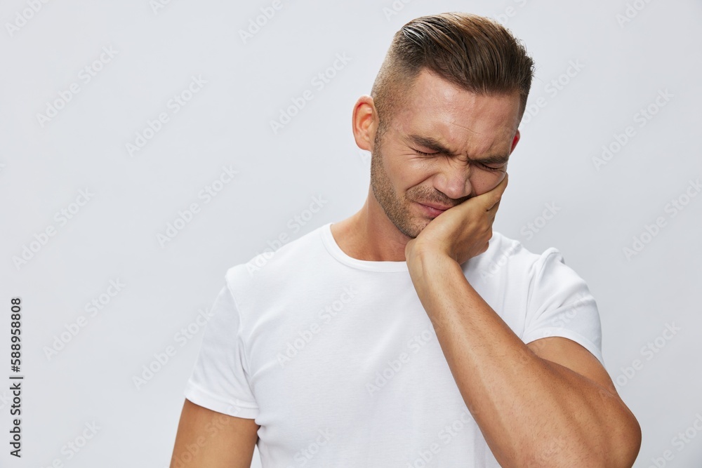 Man toothache, wisdom tooth gum inflammation, in white T-shirt on white isolated background, copy space Man toothache, wisdom tooth gum inflammation, in white T-shirt on white isolated background, copy space