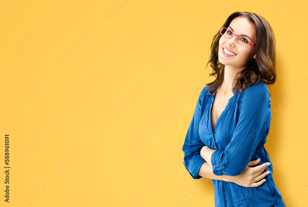 Portrait of happy smiling brunette woman looking up, in red eye glasses, blue confident wear, isolated orange yellow background. Studio portrait image. Copy space blank area. Portrait of happy smiling brunette woman looking up, in red eye glasses, blue confident wear, isolated orange yellow background. Studio portrait image. Copy space blank area.