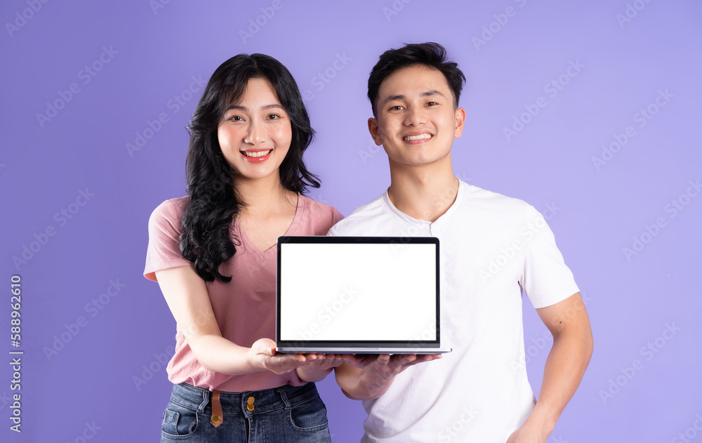 image of asian couple using laptop, isolated on purple background image of asian couple using laptop, isolated on purple background
