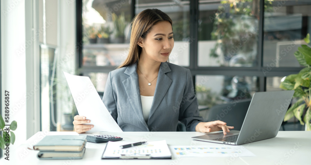 Asian businesswoman sit at their desks and calculate financial graphs showing results about their investments, plan a successful business growth process Asian businesswoman sit at their desks and calculate financial graphs showing results about their investments, plan a successful business growth process