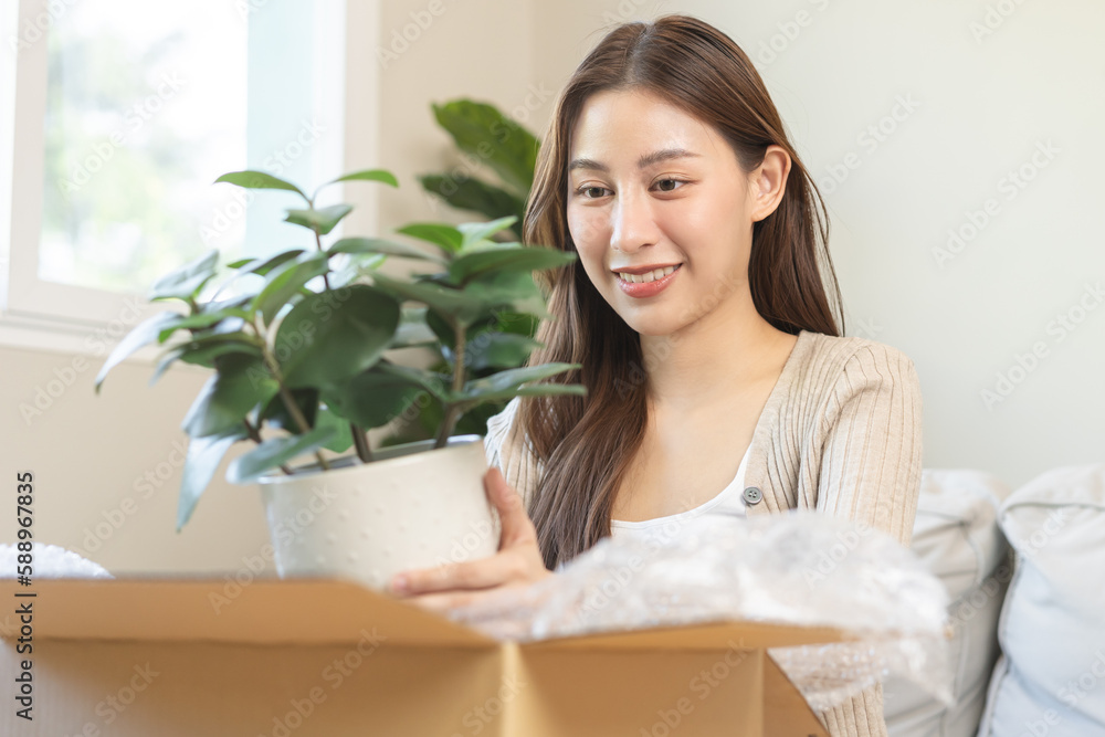 Asian young customer woman hand in received, unpack package carton open parcel in cardboard box, holding ceramic plant pot. Moving, preparing in new house, relocation. Online shop delivery at home. Asian young customer woman hand in received, unpack package carton open parcel in cardboard box, holding ceramic plant pot. Moving, preparing in new house, relocation. Online shop delivery at home.