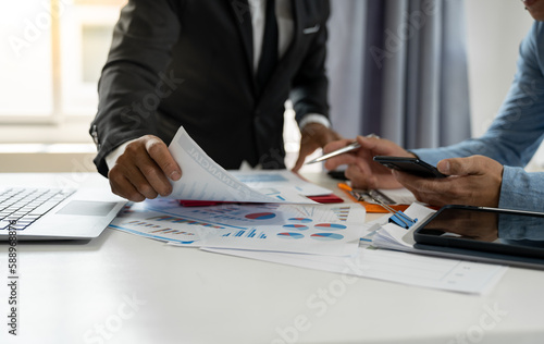 A group of businessmen, investors are brainstorming and discussing numbers in company financial papers. data analyst from laptop Graph statistics to check account management concept.