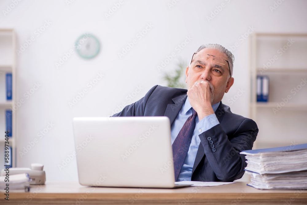 Old male employee working in the office Old male employee working in the office