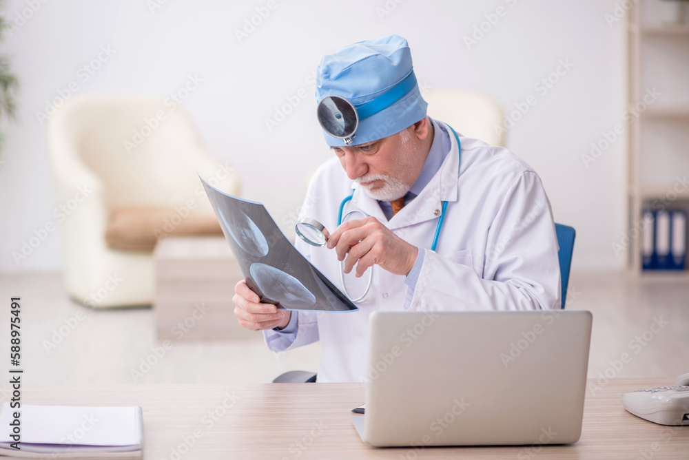 Old male doctor otologist working in the clinic Old male doctor otologist working in the clinic