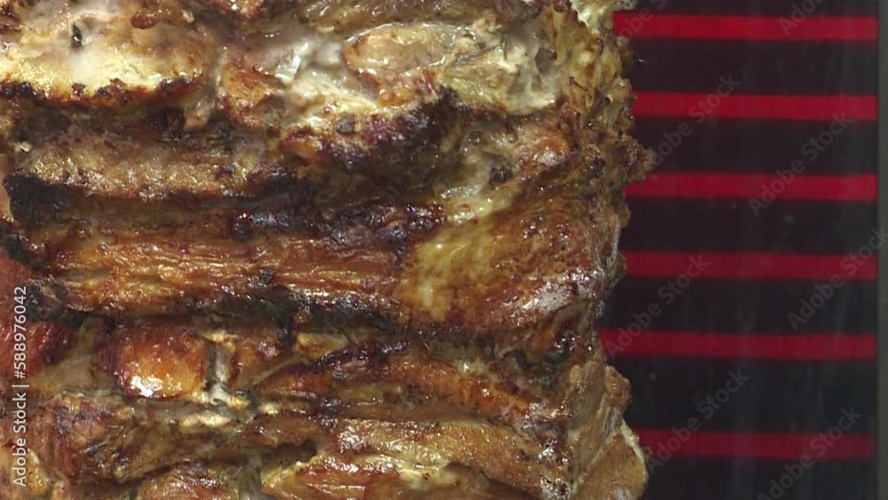 Meat on a spit . Cooking doner kebab or shawarma on a rotating vertical spit. Traditional street