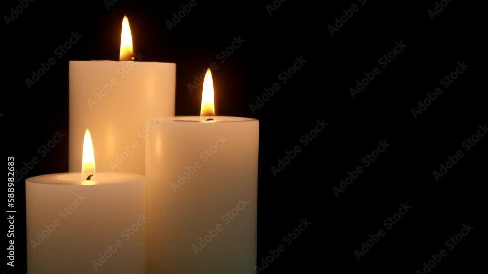 Three white candles burning on black background. Copy space for text. Three white candles burning on black background. Copy space for text.