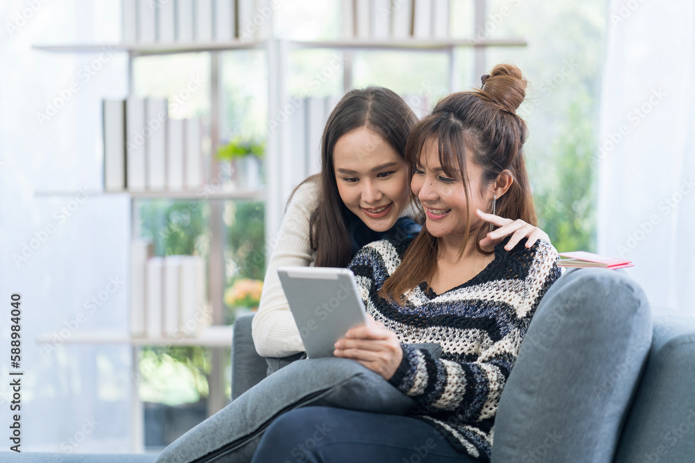 Young women couples using application on tablet. Woman enjoying time relaxing on sofa. Young women couples using application on tablet. Woman enjoying time relaxing on sofa.