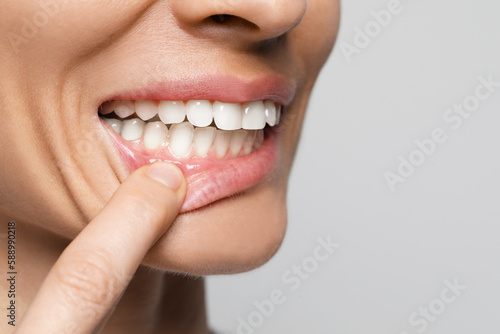 Woman showing healthy gums on light background, closeup. Space for text