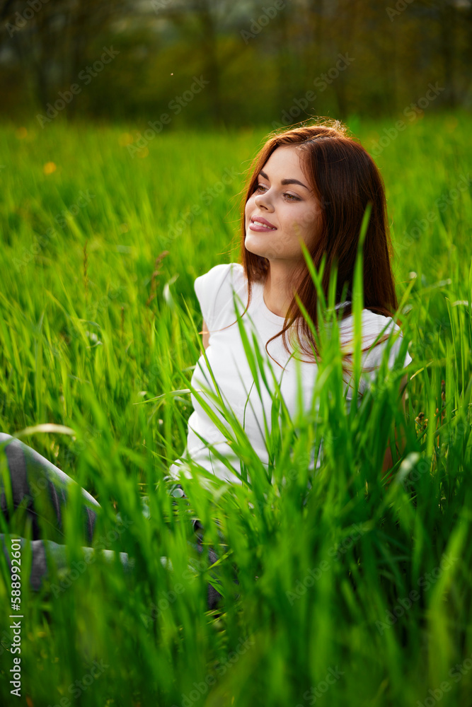 portrait of a laughing red-haired woman sitting in the grass