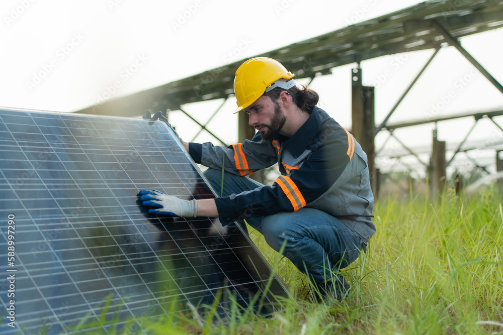 An electrical engineer is inspecting a solar cell that has been used for some time, installed on a field hundred acres of grass. An electrical engineer is inspecting a solar cell that has been used for some time, installed on a field hundred acres of grass.