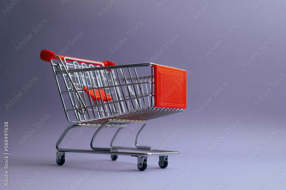 Shopping Cart on Minimal Purple Background Announcing Sale Season. Isolated empty push cart