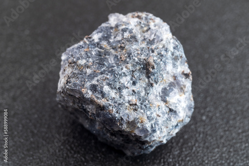 Crystal of cordierite iolite gem stone, raw mineral, black background photo
