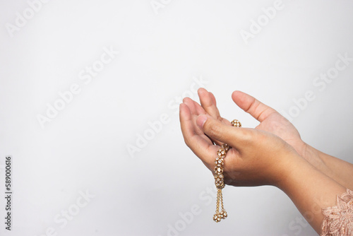 Islamic moslem woman praying with crystal tasbih wearing traditional dress