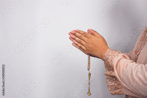 Islamic moslem woman praying with crystal tasbih wearing traditional dress