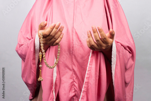 Islamic moslem woman praying with crystal tasbih wearing traditional dress