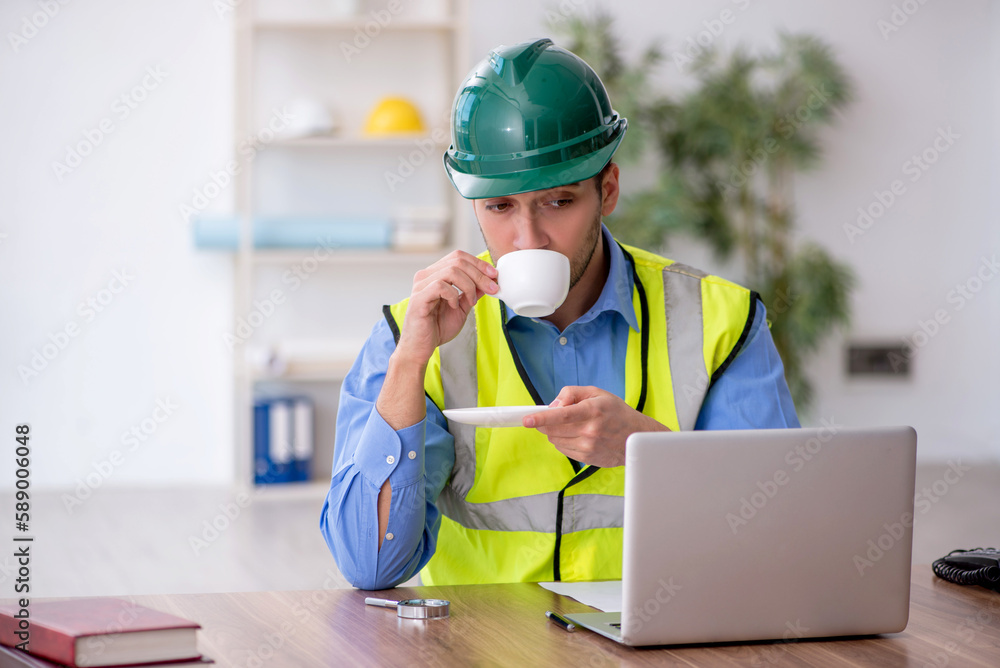 Young male architect drinking coffee during break Young male architect drinking coffee during break