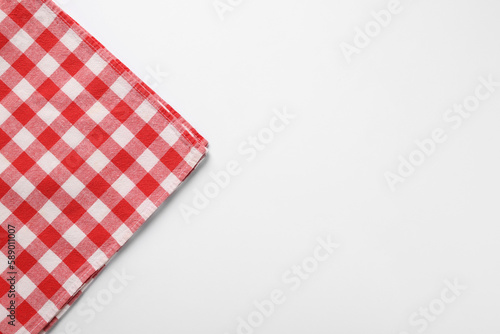 Red checkered tablecloth on white background, top view