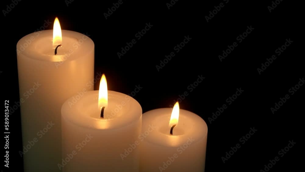 Close up of burning candles on black background. Close up of burning candles on black background.