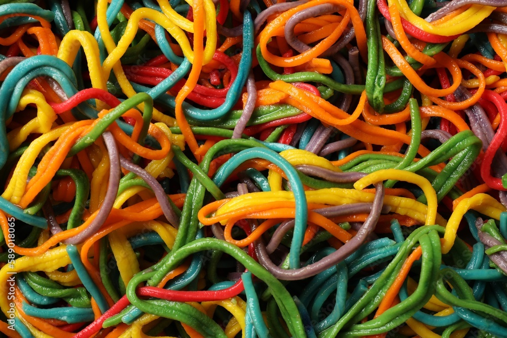 Spaghetti painted with different food colorings as background, closeup