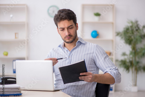 Young male employee working in the office