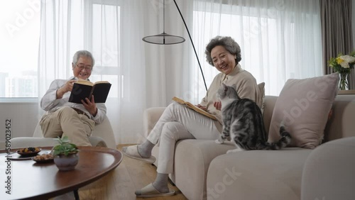 Cheerful senior couple reading book at home,4K