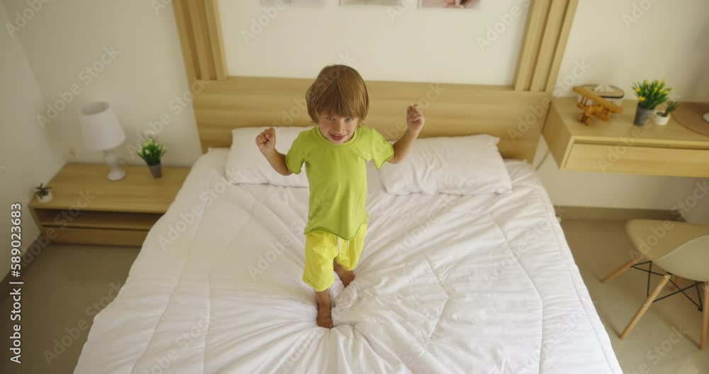 Boy wake up in the morning and jumping and falling on the bed Boy wake up in the morning and jumping and falling on the bed