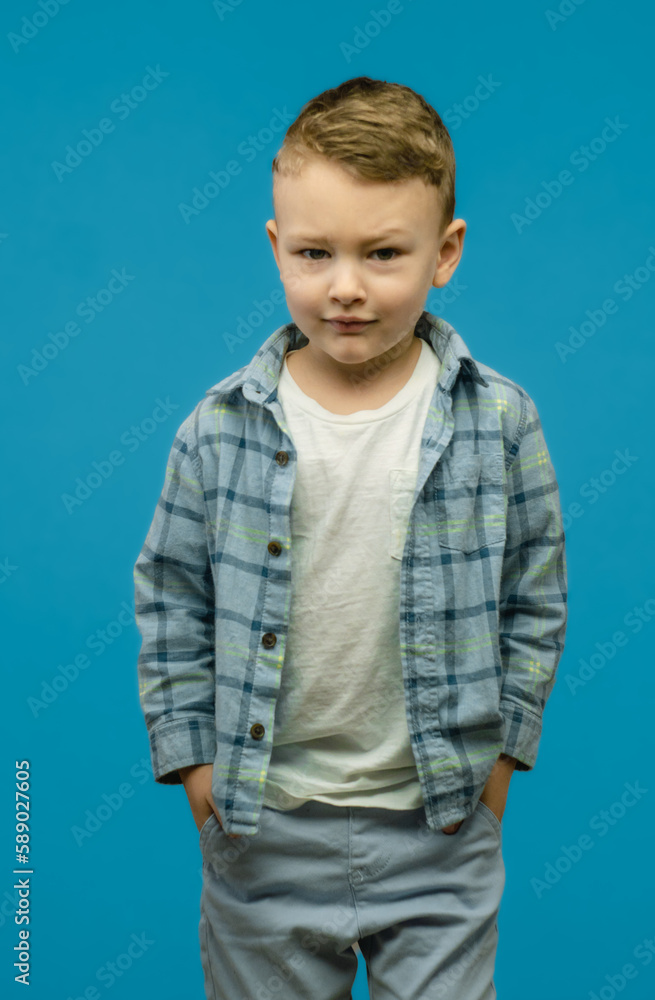 Little small smiling fun happy toddler boy wearing casual t-shirt and shirt looking camera isolated on blue background studio portrait. Little small smiling fun happy toddler boy wearing casual t-shirt and shirt looking camera isolated on blue background studio portrait.
